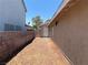 Narrow side yard with desert landscaping and access gate, providing privacy and functionality at 1501 Wintergreen Dr, Las Vegas, NV 89128