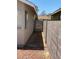 A view along the side of a home featuring desert landscaping and a wood fence in the background at 1501 Wintergreen Dr, Las Vegas, NV 89128
