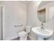 Bathroom with pedestal sink, toilet, and shower with grab bar at 1551 Echo Falls Ave, Las Vegas, NV 89183