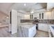 Open kitchen with white cabinets, granite island, and stainless steel appliances at 1551 Echo Falls Ave, Las Vegas, NV 89183