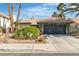 Charming single-story home featuring a low-pitch tile roof and well-maintained desert landscaping in a sunny setting at 1803 Candle Bright Dr, Henderson, NV 89074
