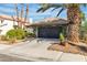 Inviting single-story home with lush landscaping, including mature palm trees, adding curb appeal to the desert property at 1803 Candle Bright Dr, Henderson, NV 89074