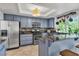 Modern kitchen boasts stainless steel appliances, granite countertops, blue cabinets, and eat-in counter seating at 1803 Candle Bright Dr, Henderson, NV 89074
