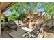 Outdoor seating area with multiple chairs, a heater, and lush greenery, perfect for relaxing in the backyard at 1803 Candle Bright Dr, Henderson, NV 89074