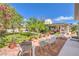 Spacious backyard with mature trees, landscaped flower beds, and paved patio with seating at 2045 S Tenaya Way, Las Vegas, NV 89117