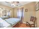 Cozy bedroom features mirrored closet doors, ceiling fan, and hardwood floors at 2045 S Tenaya Way, Las Vegas, NV 89117
