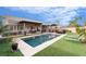 Outdoor living space with a sparkling pool, patio area, and lush landscaping at 2144 Paganini Ave, Henderson, NV 89052