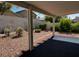 View of a gravel backyard including an outdoor seating area for dining al fresco at 2419 Pebble Springs Ct, Henderson, NV 89074