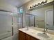 Bright bathroom featuring a double sink vanity, framed mirrors, and a shower over tub at 2419 Pebble Springs Ct, Henderson, NV 89074