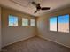 Neutral bedroom features carpet flooring, a ceiling fan, and three windows offering ample natural light at 2419 Pebble Springs Ct, Henderson, NV 89074