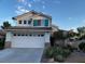 Charming two-story home featuring a two-car garage, tile roof, and landscaped front yard, offering both curb appeal and functionality at 2419 Pebble Springs Ct, Henderson, NV 89074