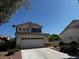 Two-story home with a well-maintained lawn and a two-car garage under a clear blue sky at 2419 Pebble Springs Ct, Henderson, NV 89074