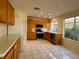 Well-lit kitchen with wood cabinets, tile floors, and stainless steel appliances at 2419 Pebble Springs Ct, Henderson, NV 89074