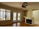 Spacious living room with hardwood floors, fireplace, and natural light from the windows and French doors at 2419 Pebble Springs Ct, Henderson, NV 89074