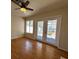 Bright living room featuring hardwood floors, ceiling fan, large windows, and French doors to the backyard at 2419 Pebble Springs Ct, Henderson, NV 89074