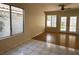 Bright living room with tile and hardwood flooring, large windows, and French doors leading to the backyard at 2419 Pebble Springs Ct, Henderson, NV 89074