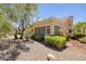 Backyard with desert landscaping, including rocks and bushes, surrounding the property at 2420 Desert Butte Dr, Las Vegas, NV 89134