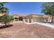 Tan single-story home with a red tiled roof and a front yard featuring desert landscaping at 2420 Desert Butte Dr, Las Vegas, NV 89134