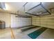 Garage with overhead racks, built-in cabinets, and epoxy floor with designated parking spaces at 2420 Desert Butte Dr, Las Vegas, NV 89134