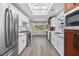 Stylish kitchen with stainless steel appliances, marble countertops, white cabinets, and wood-look floors at 2420 Desert Butte Dr, Las Vegas, NV 89134