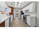 Updated kitchen with stainless steel appliances, white cabinets, marble countertops and wood-look flooring at 2420 Desert Butte Dr, Las Vegas, NV 89134