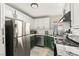 Modern kitchen with stainless steel appliances, granite countertops, and stylish green cabinets at 2569 Paradise Village Way, Las Vegas, NV 89120