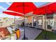 Charming backyard patio with comfortable seating, red umbrellas, and access to the home through sliding glass doors at 2569 Paradise Village Way, Las Vegas, NV 89120