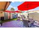 Relaxing patio area includes outdoor seating, colorful umbrellas, and well-maintained artificial grass at 2569 Paradise Village Way, Las Vegas, NV 89120