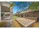 Secluded backyard featuring a brick patio, lush greenery, and desert landscaping at 26 Costa Tropical Dr, Henderson, NV 89011