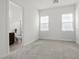 Clean bedroom with two windows, neutral carpet, and an ensuite bathroom at 26 Costa Tropical Dr, Henderson, NV 89011