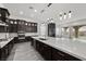 Modern open kitchen with gray wood floors, a white countertops, and stainless steel appliances at 26 Costa Tropical Dr, Henderson, NV 89011