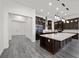 Bright, open kitchen with quartz countertop island and custom, dark wood cabinets at 26 Costa Tropical Dr, Henderson, NV 89011