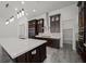 A modern kitchen with dark cabinets, a large island, stainless steel appliances, and a walk-in pantry at 26 Costa Tropical Dr, Henderson, NV 89011