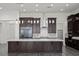 Modern kitchen featuring a white countertop island, dark wood cabinets, and stainless steel appliances at 26 Costa Tropical Dr, Henderson, NV 89011