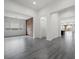 Spacious living room with grey wood flooring, large windows, and a decorative stone wall at 26 Costa Tropical Dr, Henderson, NV 89011