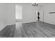 Large living room with grey wood floors and a doorway to the kitchen at 26 Costa Tropical Dr, Henderson, NV 89011