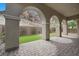 Covered patio featuring arched columns, a stone-paved floor and grass at 26 Costa Tropical Dr, Henderson, NV 89011