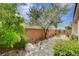 Charming backyard with a stone walkway, brick wall, mature trees, and lush green plants at 2808 Cygnus St, Las Vegas, NV 89117