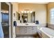 Bright bathroom with double sinks, soaking tub, and a glass-enclosed shower at 2808 Cygnus St, Las Vegas, NV 89117