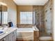 Bright bathroom with double sinks, soaking tub, and a glass-enclosed shower at 2808 Cygnus St, Las Vegas, NV 89117