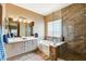 Bright bathroom with double sinks, soaking tub, and a glass-enclosed shower at 2808 Cygnus St, Las Vegas, NV 89117