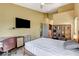Bright bedroom featuring a desk, a TV, a ceiling fan, and an ensuite bathroom at 2808 Cygnus St, Las Vegas, NV 89117