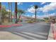 Well-maintained community entrance with a security gate, lush landscaping, and palm trees at 2808 Cygnus St, Las Vegas, NV 89117