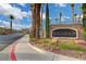 Inviting community entrance with landscaped grounds, mature palm trees, and a decorative Aurora sign at 2808 Cygnus St, Las Vegas, NV 89117