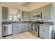 Modern kitchen featuring sage cabinetry, stainless steel appliances, and an open serving counter at 2808 Cygnus St, Las Vegas, NV 89117
