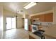 Bright kitchen featuring tile floors, wood cabinets, white appliances, pantry and a sliding glass door at 2839 Kensington St, Las Vegas, NV 89156