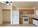Practical kitchen with wooden cabinets, white appliances, tiled floors, and pantry shelving at 2839 Kensington St, Las Vegas, NV 89156