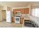Functional kitchen boasts wood cabinets, a white gas range, and a double sink with tiled flooring at 2839 Kensington St, Las Vegas, NV 89156