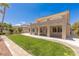 Expansive backyard with lush lawn, patio, and neutral stucco exterior provides space for entertaining and relaxation at 2846 Barrow Downs St, Las Vegas, NV 89135