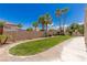 Green backyard featuring a lush lawn, complemented by mature palm trees, and bordered by a decorative block wall at 2846 Barrow Downs St, Las Vegas, NV 89135
